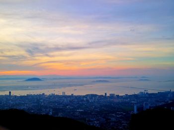 Silhouette cityscape against sky during sunset