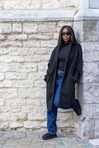 Portrait of woman standing against wall