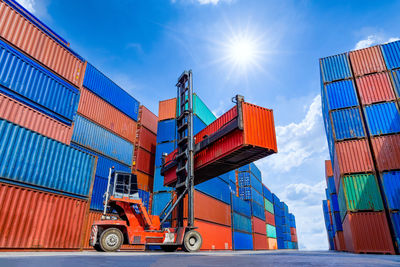 Low angle view of forklift at dock against sky