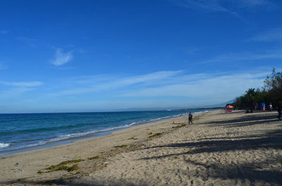 Scenic view of beach against blue sky