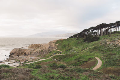 Scenic view of landscape by sea against sky