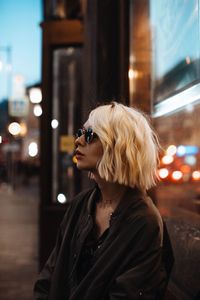 Portrait of young woman in illuminated city