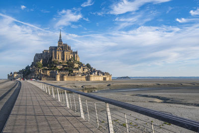 View of building by sea against cloudy sky