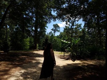 Rear view of woman walking in forest