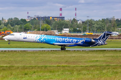 Side view of airplane on runway against sky