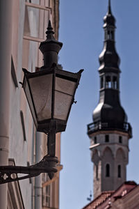 Low angle view of street light against bell tower