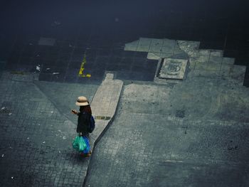 High angle view of woman walking on road in city