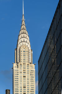 Low angle view of skyscrapers against blue sky