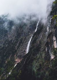 Low angle view of waterfall on rocky mountains