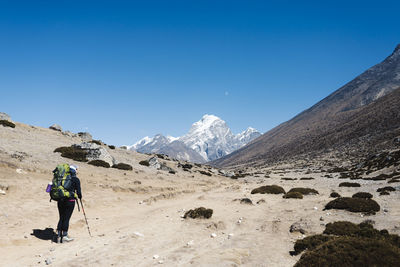 Full length of man on snowcapped mountain against clear blue sky