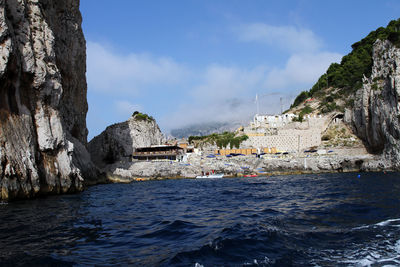 Scenic view of sea by rock formation against sky