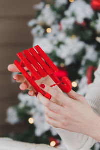 Close-up of hand holding red christmas tree