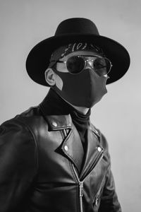 Portrait of man wearing sunglasses standing against white background