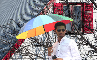 Portrait of young man holding umbrella