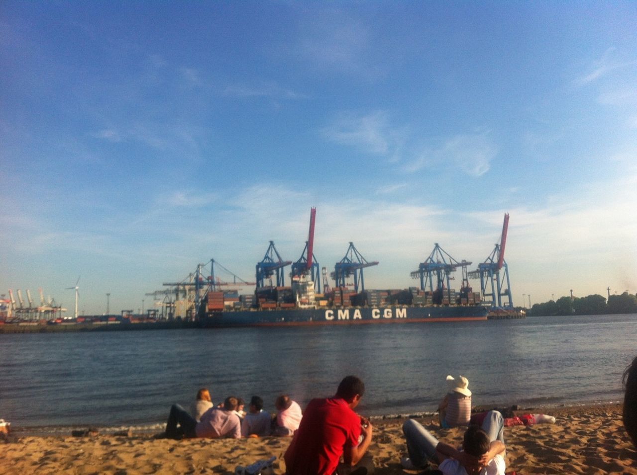 water, lifestyles, sky, men, leisure activity, sea, built structure, nautical vessel, person, architecture, harbor, building exterior, togetherness, rear view, standing, pier, sitting, cloud - sky, commercial dock