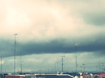 Sailboats on street against cloudy sky