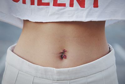 Midsection of woman with pierced belly button