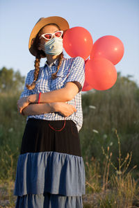 Low section of man with balloons standing on field