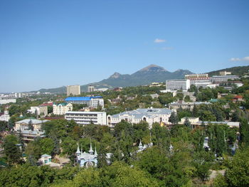 Buildings in town against clear blue sky