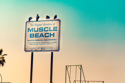 Low angle view of signboard against clear sky