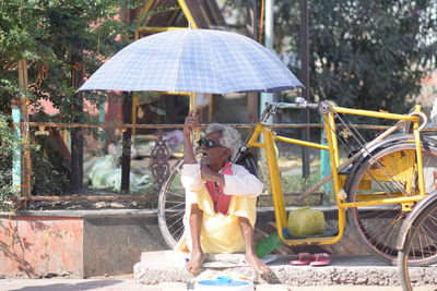 Woman sitting with umbrella