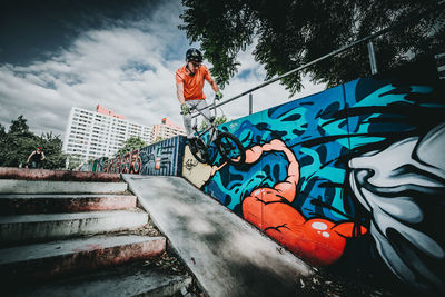 Low angle view of graffiti on staircase against sky