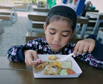 Girl eating food on table