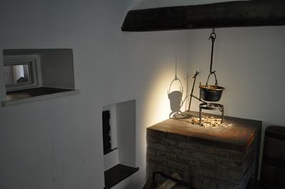 Illuminated electric lamp on table against wall at home