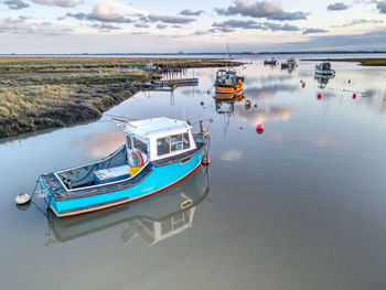 Boats moored in sea against sky