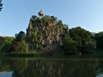 View of building by lake against sky