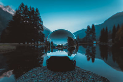 Close-up of crystal ball against sky
