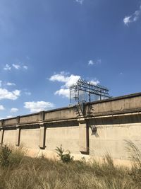 Low angle view of bridge on field against sky