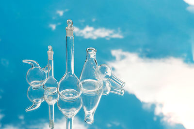 Various laboratory glassware on a mirror background with sky reflection