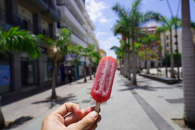 Midsection of person holding ice cream in city