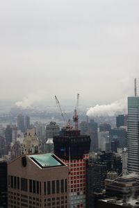 Aerial view of buildings in city against sky