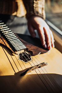 Domra folk musical instrument. female hands with 4 strings natural wood handmade musical instrument