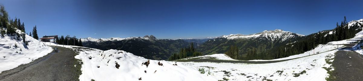 Panoramic view of snowcapped mountains against clear blue sky