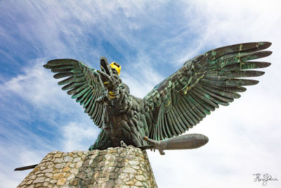 Low angle view of bird statue against sky