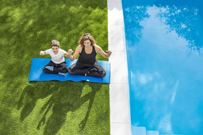 Mother and son doing yoga exercises in their home garden