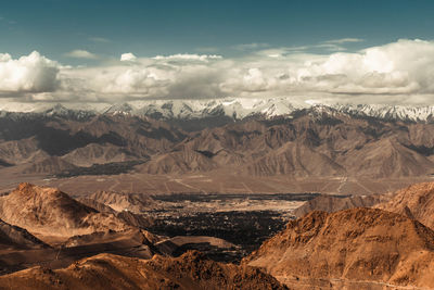 Scenic view of snowcapped mountains against cloudy sky