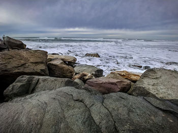 Rocks on beach against sky