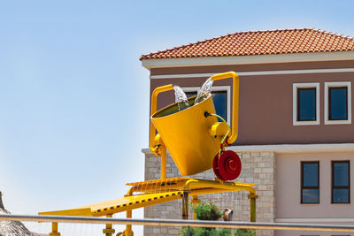 Low angle view of yellow building against clear sky