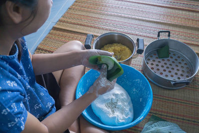 Midsection of woman with umbrella in kitchen