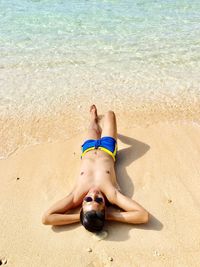 Low section of woman relaxing on beach