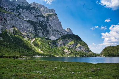 Scenic view of lake by mountains against sky