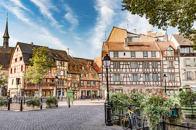 Houses by street in town against sky