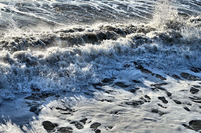 High angle view of waves rushing towards shore