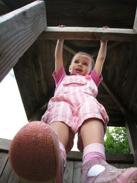 Low angle view of boy standing by railing