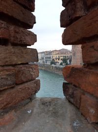 Stack of old building by river against sky