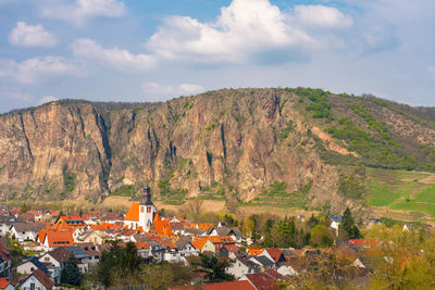 Scenic view of townscape and mountains against sky